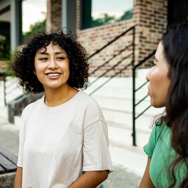 Two women outside on steps. Photo: Unsplash